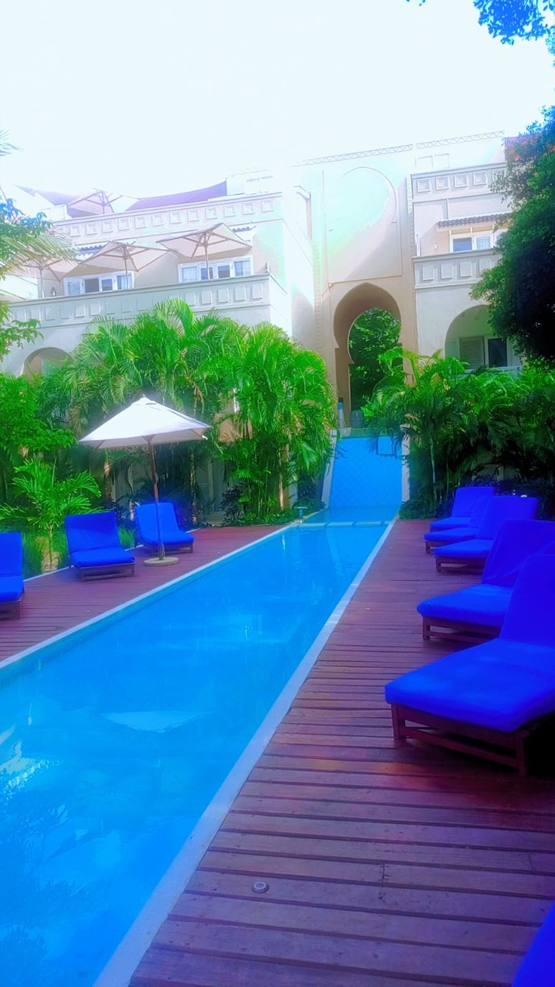 Pool, palms and Moorish archway